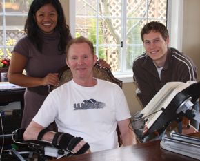 Michael (seated) keeps his right arm in a comfortable position with this customized armrest. He is joined by Tricia and Brandon.