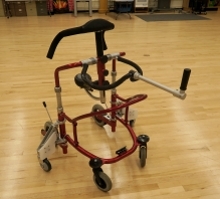 The modified gait trainer has added wheels for stability on uneven terrain.